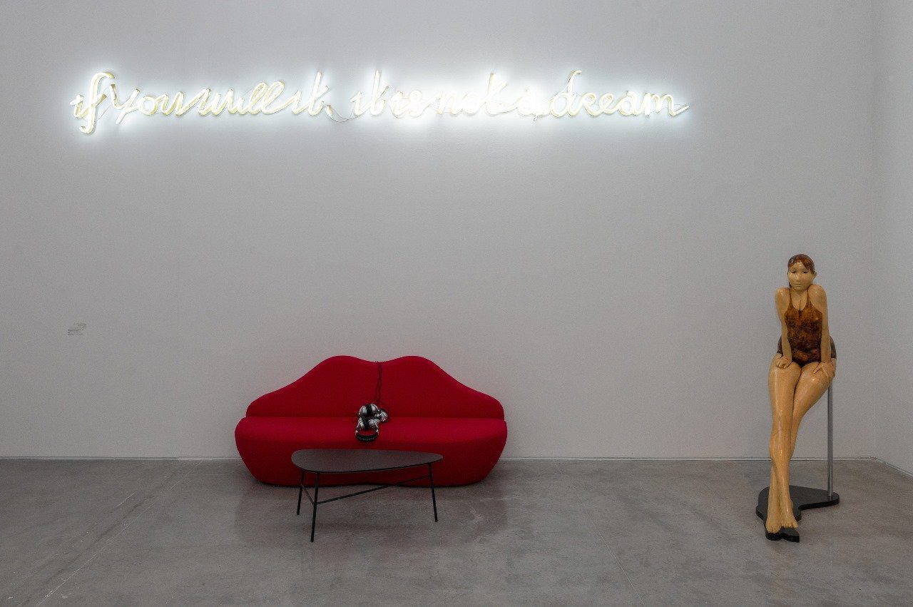 פסל של פרנק גלו ועבודת נאון של יעל ברתנא, מעל ספה בהשראת סלבדור דאלי