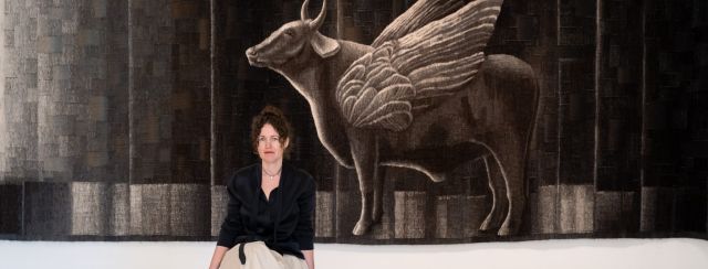 נגה ברנשטיין על רקע העבודה של אלכסנדרה סטויאנוב. צילום: יובל נאור