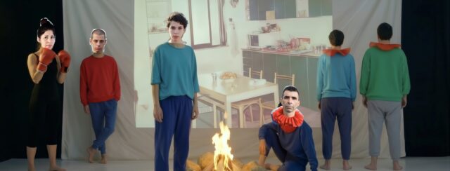 אילנית שמיע, אישה עומדת מחזיקה מחבקת את עצמה מהגב. סטילס מתוך וידיאו